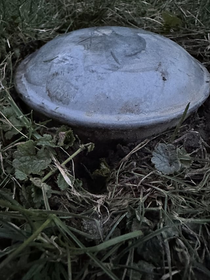 I recently bought a new house and this is in my backyard. Looks like a cap of some sort, about 6 inches in diameter. Feels like metal and is embedded into the ground